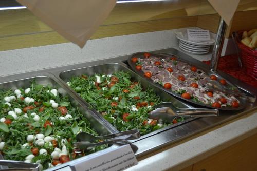 a buffet with two trays of lettuce and tomatoes at Eraclea Palace Hotel 4 stelle S in Eraclea Mare