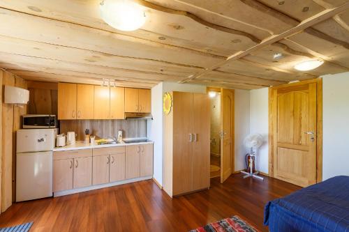 a kitchen with wooden ceilings and a room with a bed at Sodyba Brazylija in Taraldžiai