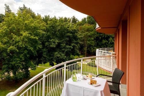 a table on a balcony with a white tablecloth on it at Hotel Svět in Třeboň