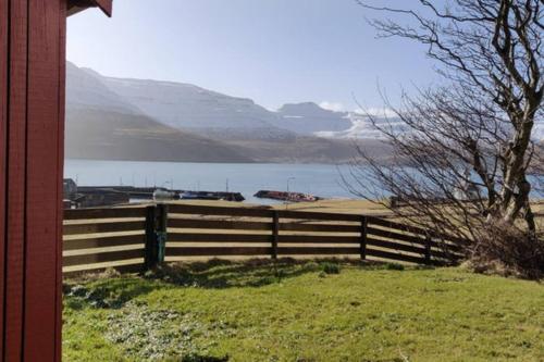 a fence with a view of a lake and mountains at Holidayhouse by the sea in Selatrað