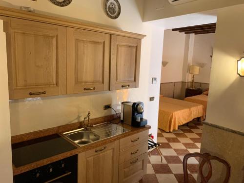 uma cozinha com um lavatório e uma cama num quarto em Luxury Apartment in San Marco with Canal View em Veneza