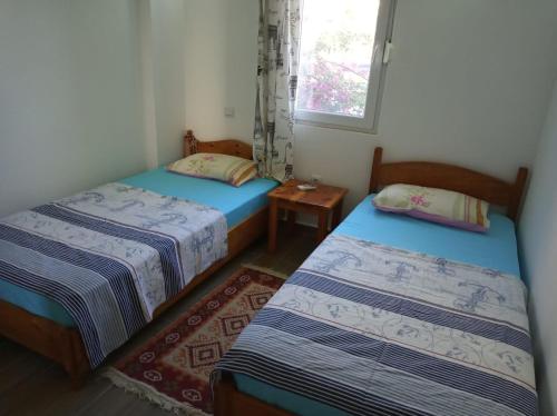 a room with two beds and a window at Heybe Apart in Kaş