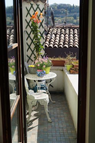 una mesa y una silla en un balcón con flores en In the heart of Verona, en Verona