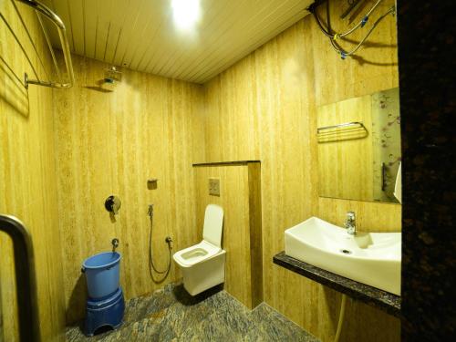 een badkamer met een toilet en een wastafel bij The Royal Paradise Resort and Salt Yard in Bīr
