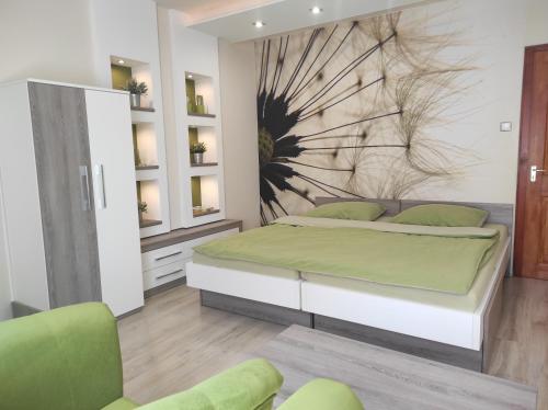 a bedroom with a large bed and two chairs at RP FitLife Stúdió és Vendégház in Szentgál