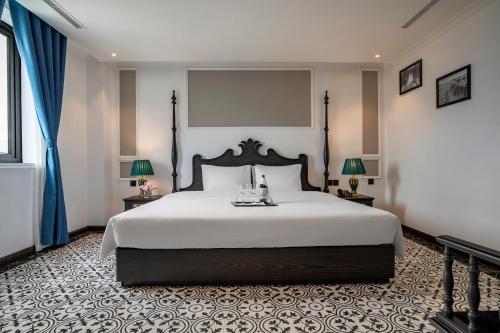 a bedroom with a large white bed and two lamps at Ha Long Essence Hotel in Ha Long