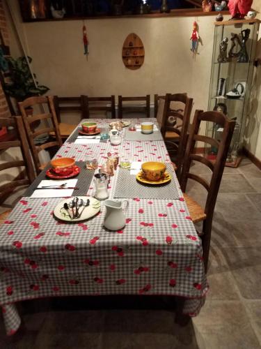 una mesa con un mantel estampado en rojo y blanco en Ferme bressane les Arums en Mervans