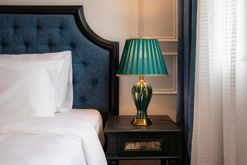a lamp on a night stand next to a bed at Ha Long Essence Hotel in Ha Long
