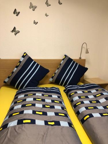Schlafzimmer mit einem Bett mit blauen und gelben Kissen in der Unterkunft Ferienwohnung Seesicht in Brunnen