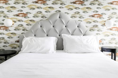 a bedroom with a white bed with a wallpaper at Belvedere in Stresa