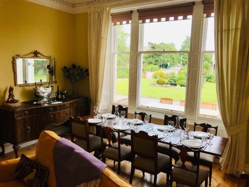 a dining room with a table and a large window at Lairds Lodge Inverness in Inverness