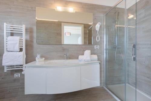a bathroom with a white sink and a shower at Eraclea Palace Hotel 4 stelle S in Eraclea Mare