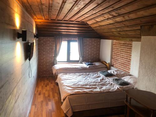 two beds in a room with a brick wall at Александрова вила 1 in Zlatograd