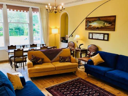 a living room with a blue couch and a dining room at Lairds Lodge Inverness in Inverness