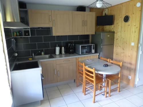 une petite cuisine avec une table et des chaises. dans l'établissement studio Morillon village, à Morillon