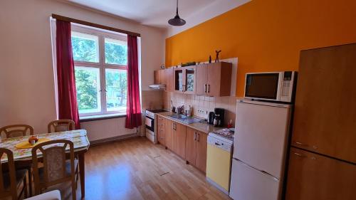eine Küche mit einem weißen Kühlschrank und einem Tisch in der Unterkunft Café Dlask in Varnsdorf