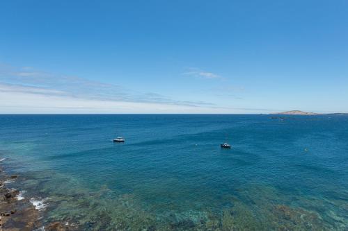 two boats in the water next to a beach at Penthouse with Private Swimming Pool in Melenara