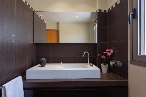 a bathroom with a white sink and a mirror at Penthouse with Private Swimming Pool in Melenara
