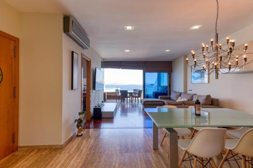 a living room and dining room with a table and chairs at Penthouse with Private Swimming Pool in Melenara