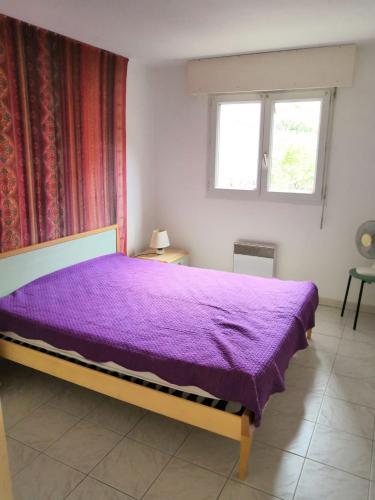 - une chambre avec un lit violet et une fenêtre dans l'établissement Vue sur Port Fréjus, à Fréjus