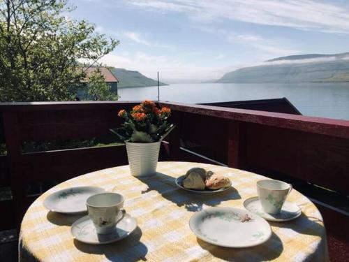 a table with plates and cups and a vase at Holidayhouse by the sea in Selatrað