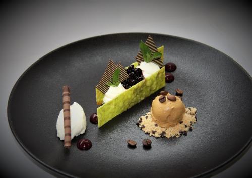 two desserts on a black plate on a table at BRUGGER'S Hotelpark am See in Titisee-Neustadt