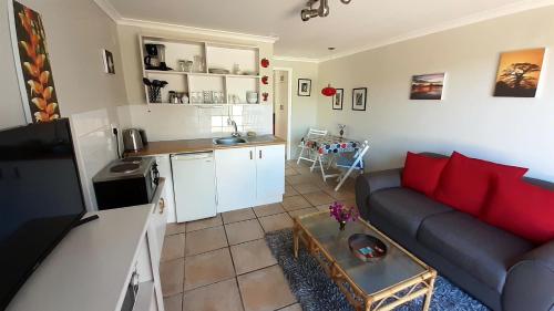 a living room with a couch and a kitchen at Self catering Holiday Apartment in Glencairn