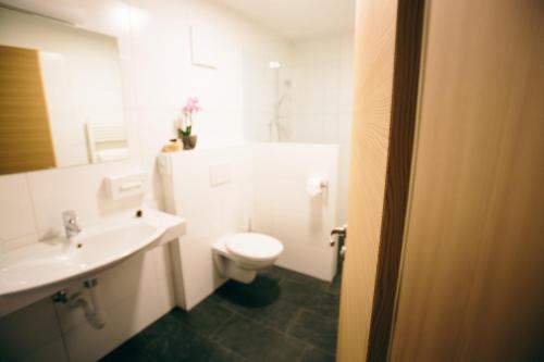 uma casa de banho com um WC branco e um lavatório. em Gasthof Schönau em Moso