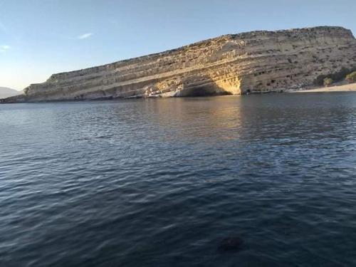 a large body of water with a rock formation at Alexandra`s House in Matala