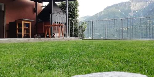 einen Hof mit grünem Gras und einem Zaun in der Unterkunft CASA GIo in Aosta