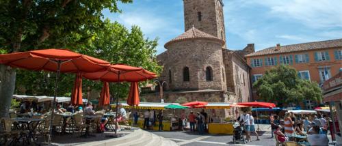 un groupe de personnes assises à des tables avec des parasols dans l'établissement Fréjus centre, à Fréjus