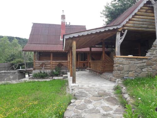 Cabaña de madera con porche y edificio en "Бджілка" і " Садиба для відпочинку", en Lyuta