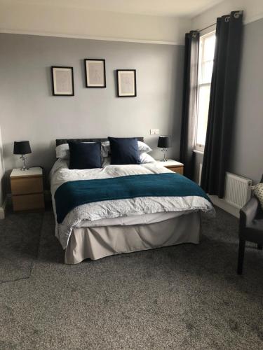 1 dormitorio con 1 cama con sábanas y almohadas azules en Carlton Guest House en Stratford-upon-Avon