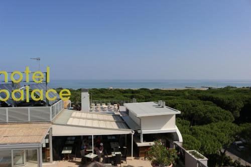 a view of a hotel with a sign and trees at Eraclea Palace Hotel 4 stelle S in Eraclea Mare