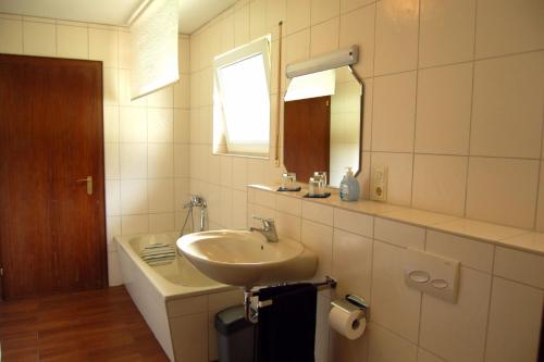 a white bathroom with a sink and a mirror at Ferienhaus - Vakantiehuis, Ferienwohnung, 100 qm, Rollmann, 54578 Nohn, Eifel- Nürburgring in Nohn