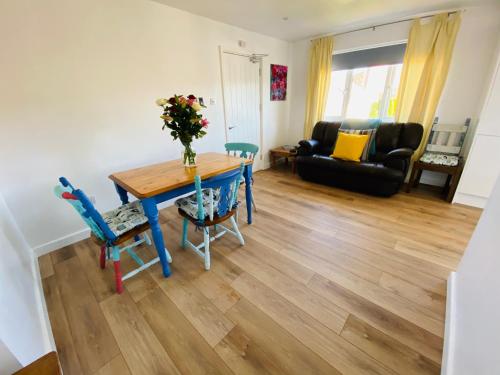 a living room with a blue table and chairs at Driftwood Seagrass in Par