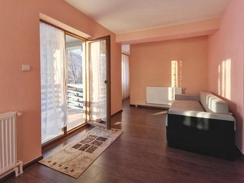 Pensiunea Magda في كامبولونغ مولدوفينيسك: غرفة معيشة مع أريكة ونافذة كبيرة