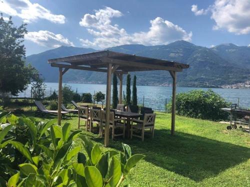 un gazebo con tavolo, sedie e un lago di Como Lake view House a Lezzeno