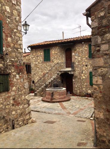 a stone building with a staircase in a courtyard at Rosa di Maggio in Pari