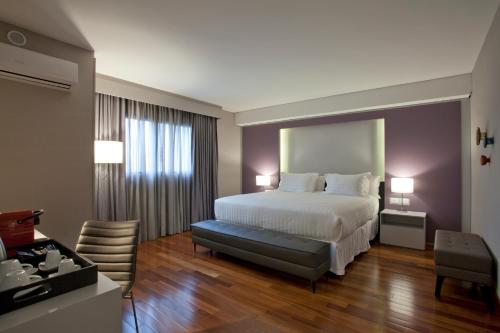 een hotelkamer met een bed en een bureau bij NH Curitiba The Five in Curitiba