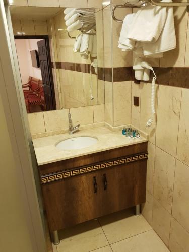 a bathroom with a sink and a mirror at Kervansaray Canakkale Hotel - Special Category in Canakkale