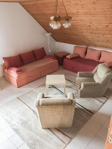 a living room with two couches and a table at Baranya Apartman in Áta
