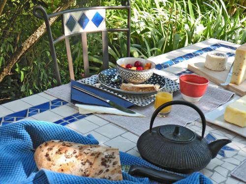 una mesa con un hervidor de agua y un plato de comida en Le Pré, en Juriens