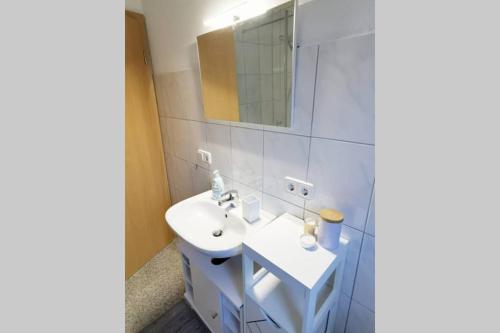 a white bathroom with a sink and a mirror at Ferienwohnung Rhode in Rielasingen-Worblingen