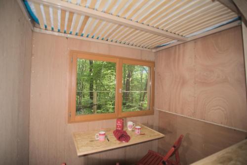 Cette chambre comprend une fenêtre, une table et des chaises. dans l'établissement Refuge ESPACE FOULETOT, à Mont-sous-Vaudrey