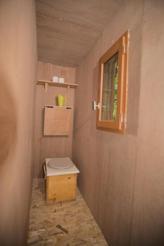 Elle comprend une petite salle de bains pourvue de toilettes et d'une fenêtre. dans l'établissement Refuge ESPACE FOULETOT, à Mont-sous-Vaudrey