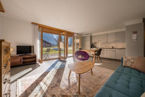 a living room with a couch and a table at Apartment Trümmelbach, Comfortabl & Cozy, Private Terrace with best views in Lauterbrunnen