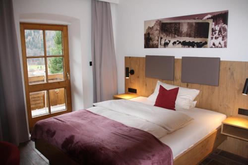 a bedroom with a large bed and a window at Zur Guten Einkehr in Bayrischzell