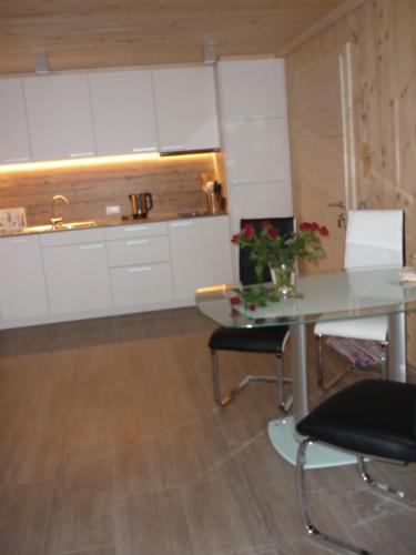 a kitchen with a table and chairs and a sink at Apartments Resi in Rasùn di Sotto