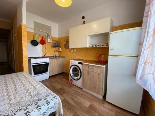 a small kitchen with a refrigerator and a washing machine at Трехкомнатные апартаменты в ЦЕНТРЕ! СОБОРНАЯ! ПАРКОВКА! 4 РАЗД МЕСТА!Мак Дональдс in Mykolaiv